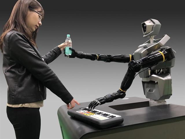 工研院展出類人雙臂機器人，擁有仿生手掌抓取形狀不規則物件，拿書、名片、手機、或寶特瓶，連彈電子琴都可以。