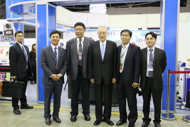 副總統吳敦義（右三）參觀展會總召董事長潘忠義之佑昇雷射公司攤位，並於雷射切焊雕複合機前合影。