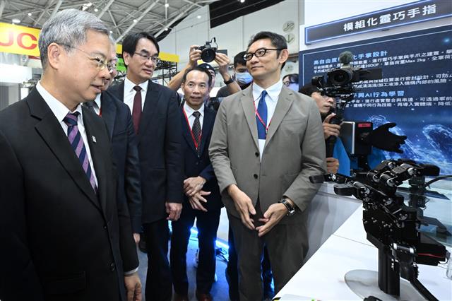 Minister of Economic Affairs Ming-Hsin Kung (left) views ITRI's AI Dexterous Robotic Hand