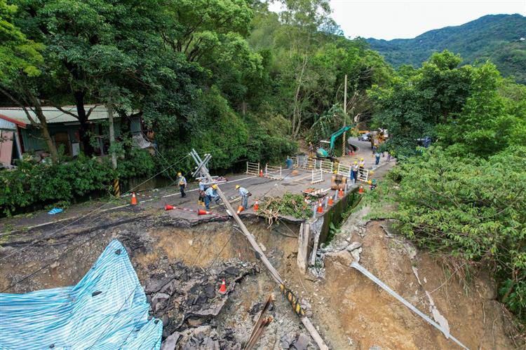 新北市三峽區北113縣道因連日豪雨致路面坍塌下陷，電桿因路基崩塌傾倒。(1/2)