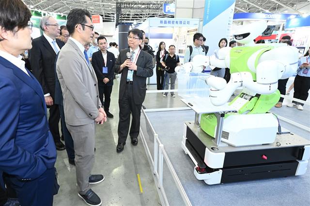 精機中心代總經理李健勲向經濟部產業技術司司長郭肇中介紹精機中心開發的「雙臂協作搬運機器人」