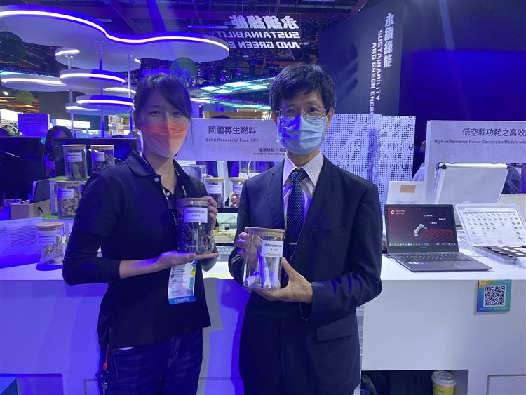 隆順綠能公司代表向陳秘順副處長(右)說明該公司如何利用廢塑膠與紡織品舊衣，再製成可取代煤碳的工業用固體再生燃料