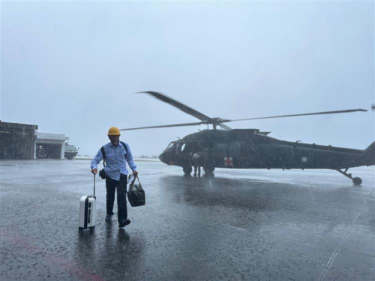 台電搶修人員搭軍機抵達蘭嶼，冒雨投入搶修。