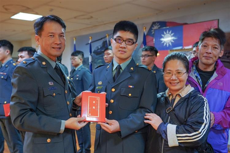 鄭濬嶸(中)因成績優異獲頒台電獎助學金，幫助他完成大學學業，現已是職業軍人。圖為鄭濬嶸晉升中士時與長官及家人合影。
