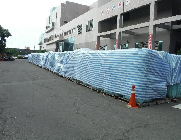 岡山焚化廠暫存的飛灰穩定化物下方放置棧板，明顯與地面隔離，並於上方覆蓋帆布，無環境二次污染的情形。