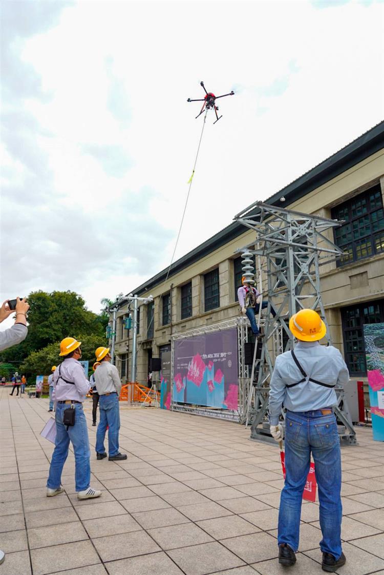 台電今日島嶼脈動文資特展開幕現場直接搬來5公尺高的Q版電塔，由台電同仁操作「無人機」展示電纜拉線作業。