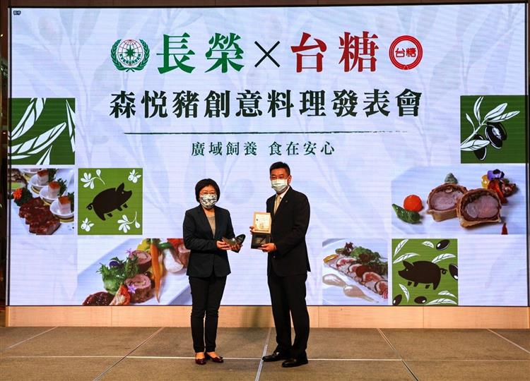 台糖公司副總經理顧孝柔(左)與長榮集團副總經理陳耀銘在今(28)日台糖森悅豬發表會中互贈鐵道丁及聚寶盆紀念品。