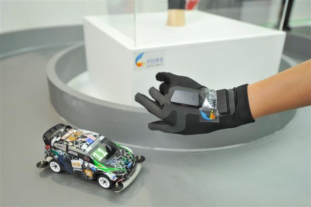 圖5 紡織所開發的「體感智慧型紡織品」可以把穿戴者的手部姿勢轉化為機械語言，操控模型汽車、無人機，未來也能應用在操作掃地機器人、健康照護、運動休閒等領域。