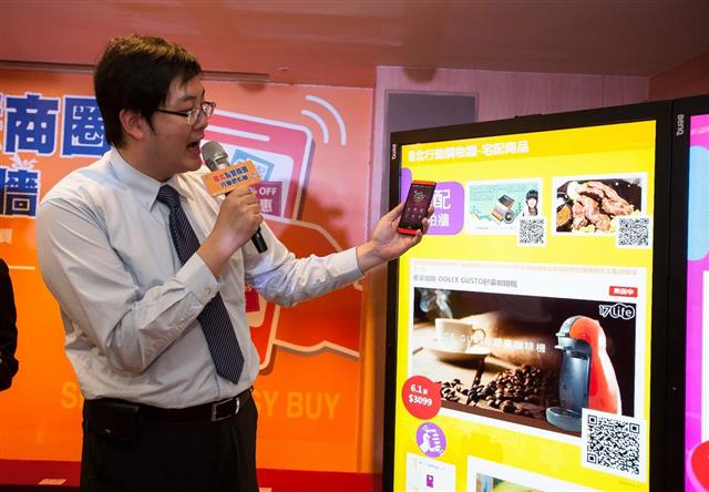 資策會創研所組長邱璟明進行行動購物牆操作說明。