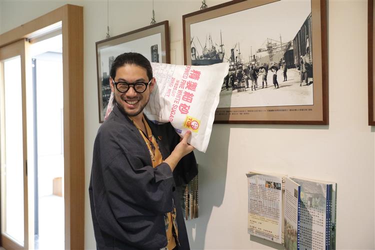 東京林檎製飴所社長池田喬俊在參訪台糖文物館時，模仿老照片中砂糖搬運工的姿態。